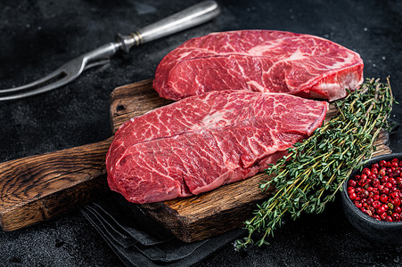 屠夫切板上的新鲜生顶刀片或扁铁牛肉牛排。