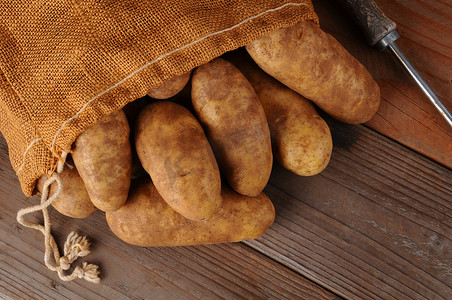 在木头上装满麻布袋的土豆