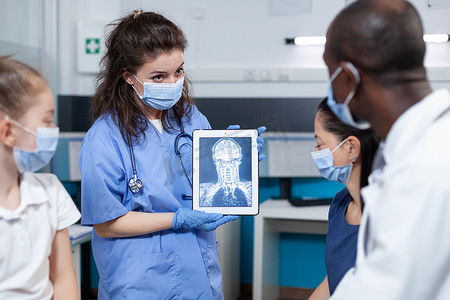 放射科医生女助理手持平板电脑显示患者放射线照相