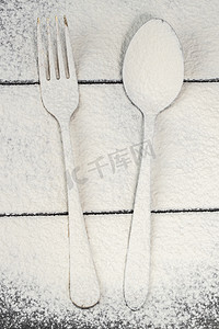 切板上的叉子和勺子撒上面粉。板上的餐具。