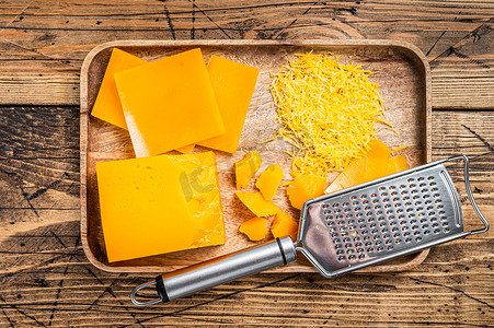 切达干酪磨碎并切块，放在木托盘中。