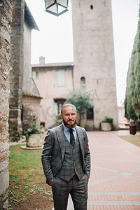 西尔苗内老城，一位留着胡子、穿着严格的灰色三件套、打着领带的男人，意大利一位穿着灰色西装的时尚男人