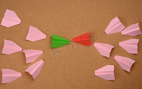 纸飞机粉色摄影照片_棕色背景上的两大组纸飞机。