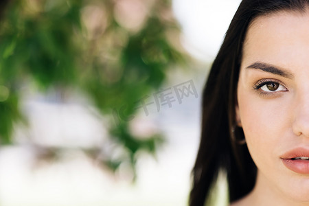 樱花美妆摄影照片_特写美丽柔软的女人的半张脸，妆容自然，看着相机。