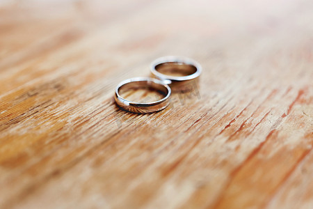 对破旧的木制背景上的金色结婚戒指。