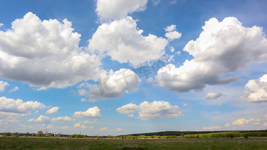 晴朗的夏季天气，没有风或雨的晴朗的蓝天，背景是白云的田野。