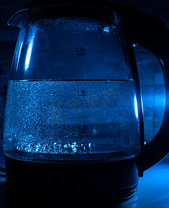 黑色 backgr 上带蓝色背光的沸腾玻璃黑茶壶