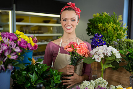 在花店里拿着一束花的女卖花人