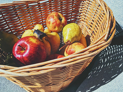 有机苹果、梨和香蕉放在柳条篮子里