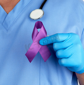 蓝色制服和乳汁手套的医生拿着一条紫色丝带