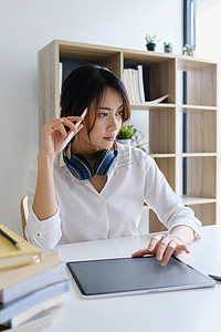 工作安排摄影照片_女性高管思考员工在联合办公空间的数字笔记本电脑中编写报告的工作安排。