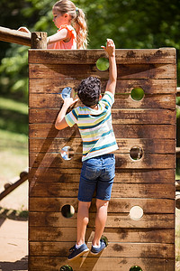 攀岩男孩摄影照片_男孩在公园的操场上攀爬