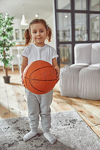 快乐的女孩在客厅打篮球