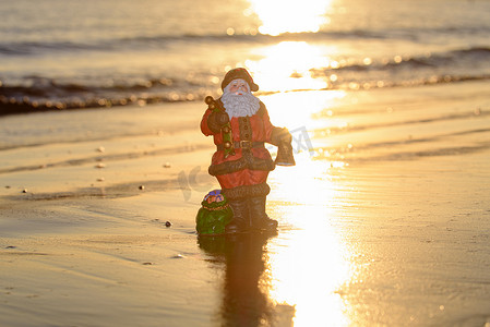 夏天圣诞老人在沙滩上日落。