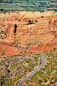 穿越峡谷摄影照片_穿越大沙漠峡谷和红色岩石悬崖的风景旅游路