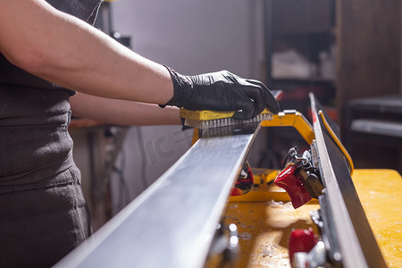 工作和修理概念 — 男人的手通过摩擦石蜡修理滑雪板