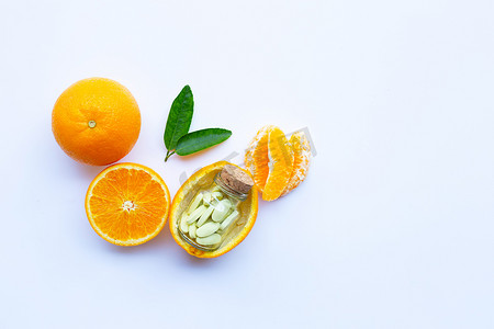 白色背景中带有橙色水果的维生素 C 瓶和药丸
