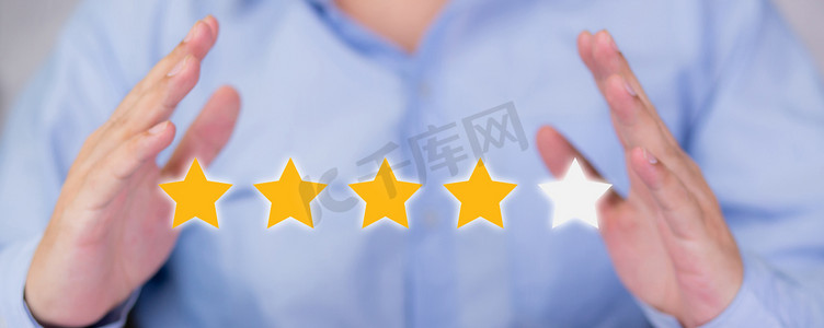 客户评分摄影照片_客户商人手持星形图标符号进行投票评分审查和反馈，质量和满意度，数字营销的成功，服务排名结果优异。