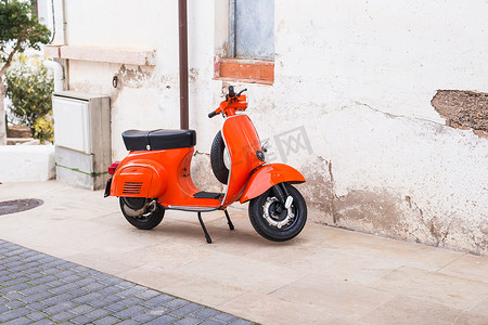 橙色摩托车 Vespa 停在西班牙巴塞罗那老街上