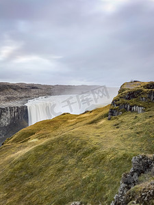 时间风摄影照片_冰岛的黛提瀑布瀑布长时间暴露在厚厚的苔藓和草丛后面的边缘