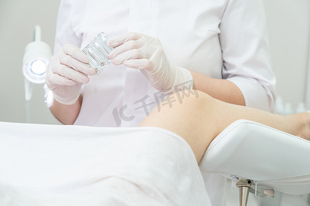 妇科医生拿着阴道栓剂在医疗椅上咨询患者