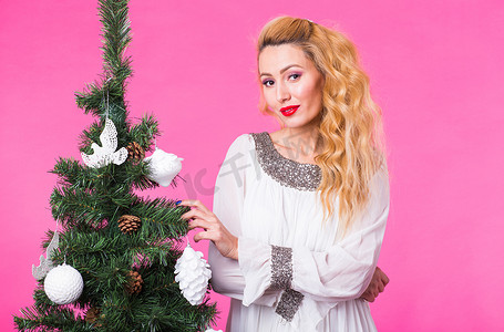 圣诞节和节日概念 — 粉红色背景圣诞树微笑的金发美女肖像