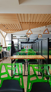 自助餐厅，没有人的餐厅，有木桌和绿色椅子。