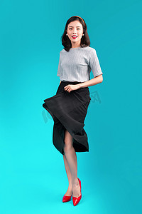 全身微笑的亚洲女性穿着蓝色的海报风格连衣裙。