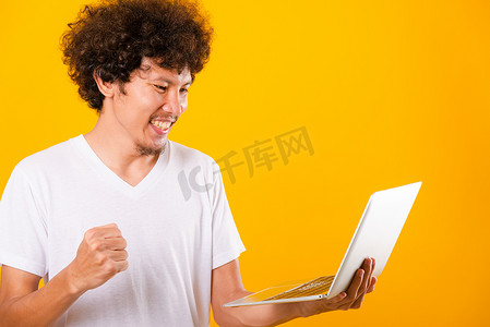一头卷发的亚洲帅哥使用笔记本电脑隔离