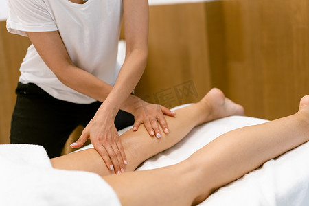中年妇女在美容院做腿部按摩。