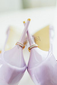 紫色新娘鞋后跟上的结婚金戒指。