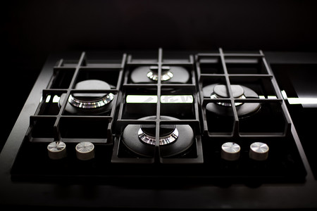 新型现代燃气灶，厨房有四个燃烧器，不锈钢表面。