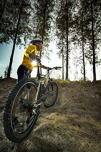 丛林扁平化摄影照片_年轻人和山地自行车在丛林赛道上用于体育活动