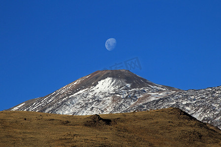 冰雪覆盖的特罗门火山与满月，阿根廷