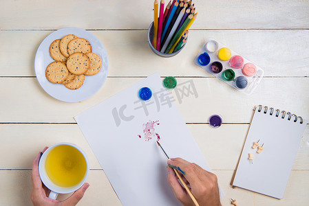 桌子上的铅笔摄影照片_桌子上的画笔、素描本和水彩颜色。