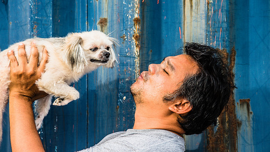 美男摄影照片_亚洲男人和狗开心地拥抱容器