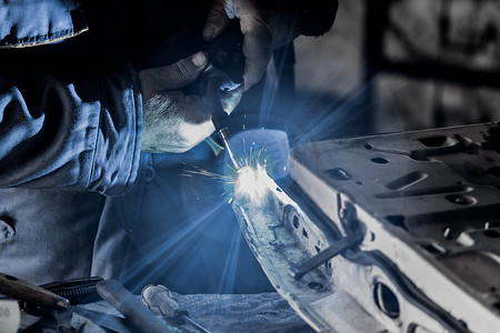 男焊工的手在工厂车间从事焊接和金属加工特写