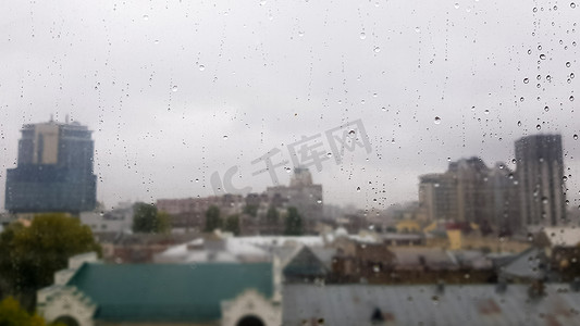 多云天气下，秋季城市背景上有滴的湿窗。