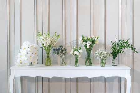 白色古董桌上花瓶中不同白花的简单组合