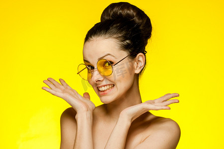 裸肩黑发美女双手靠近脸部透明皮肤黄色眼镜