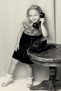 一个小女孩正在用旧电话响铃。