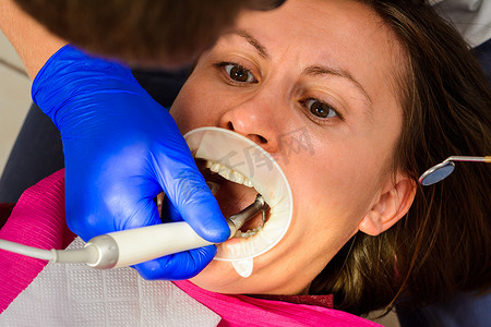 病人和牙医，咀嚼牙的检查和治疗，旧填充物的去除，牵开器的使用。