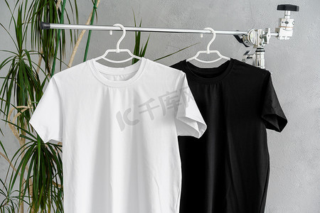 黑色t恤摄影照片_衣架上的白色和黑色 T 恤用于设计展示