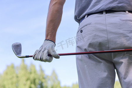 阳光明媚的日子里，用铁杆从球道上打高尔夫球。