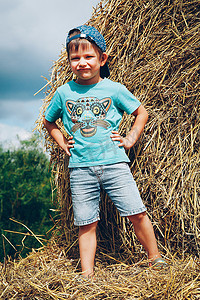 夏日，乡村的一个小男孩站在稻草堆上