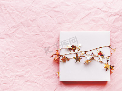 情人节礼物装在一个白色的盒子里，上面有金色的星星丝带。