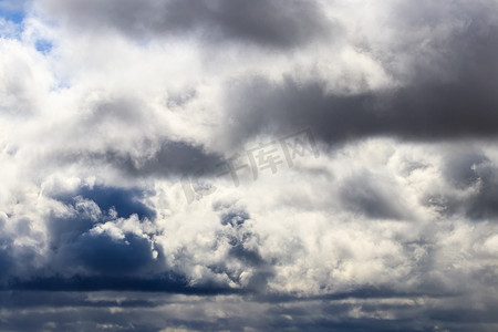 蓝色天空的云摄影照片_明亮的蓝色天空，在白天的阳光照射下，有戏剧性的积云。