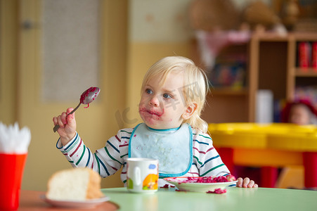 孩子在幼儿园或家里吃健康食品，弄脏了