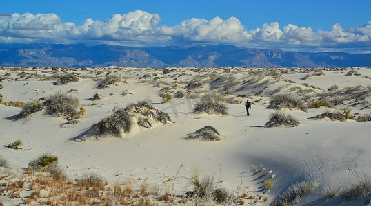 一位游客在美国新墨西哥州白沙国家纪念碑的沙丘上行走