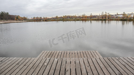 宁静湖面摄影照片_秋天有雾的早晨，安静的湖面上的一个小木码头。